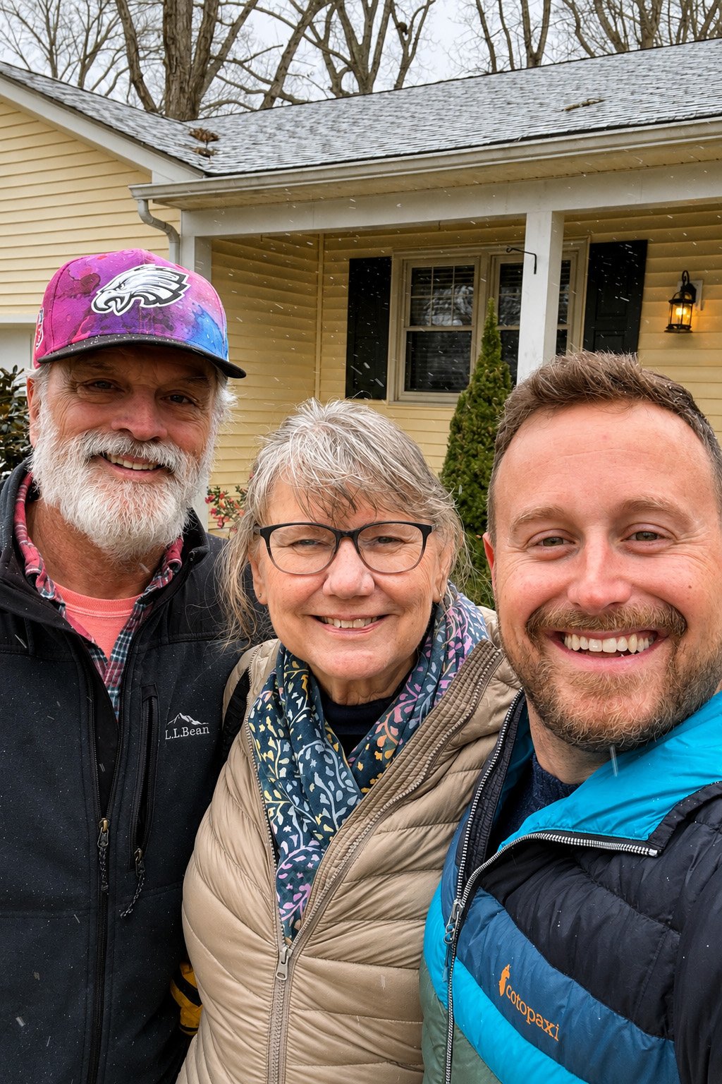 Matt Giroud with clients outside their new home on a snowy day