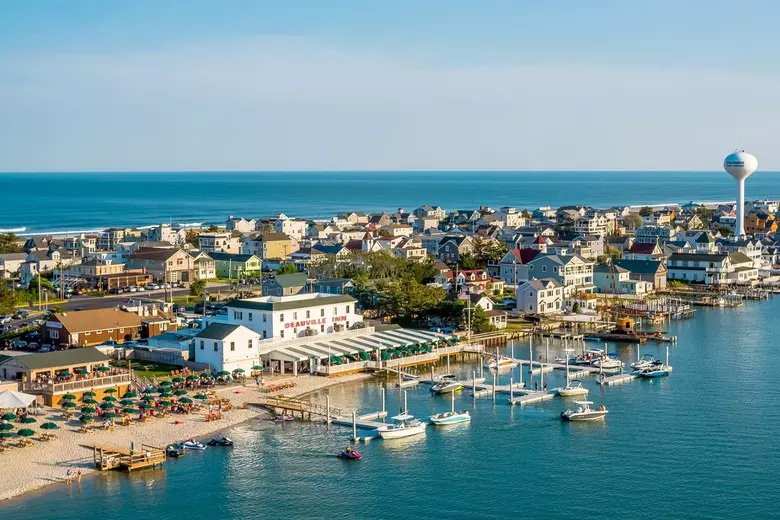 Aerial view of Strathmere, New Jersey showing the bayfront marina, homes and ocean in the background.