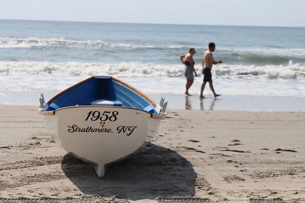 Lifeguard boat on the beach in Strathmere, New Jersey with ocean waves in the background.
